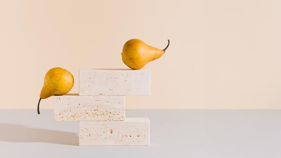 Two pears balancing on a tipping point.