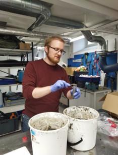 Kuvassa tutkija osittaa homogenisoitua maanäytettä pienempiin osanäytteisiin.