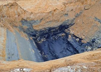 Kaivanto, jonka pohjalla näkyvissä mustaa sulfidipitoista sedimenttiä