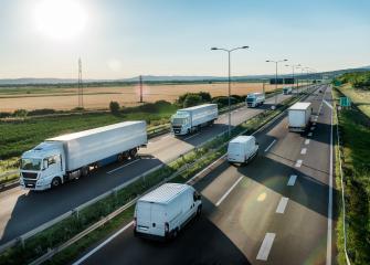 Valkoisia rekkoja ajaa aurinkoisena päivänä.