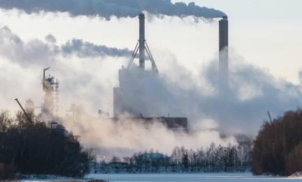 Maisemakuva savupiipuista, jotka tupruttavat paljon savua. 