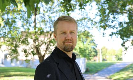 Kuvassa on Syken ilmastoratkaisut-yksikön kehittämispäällikkö Sampo Soimakallio. Taustalla on kesäinen pihamaisema.