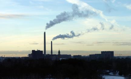 Savua nousee tehtaanpiipuista taivasta vasten.